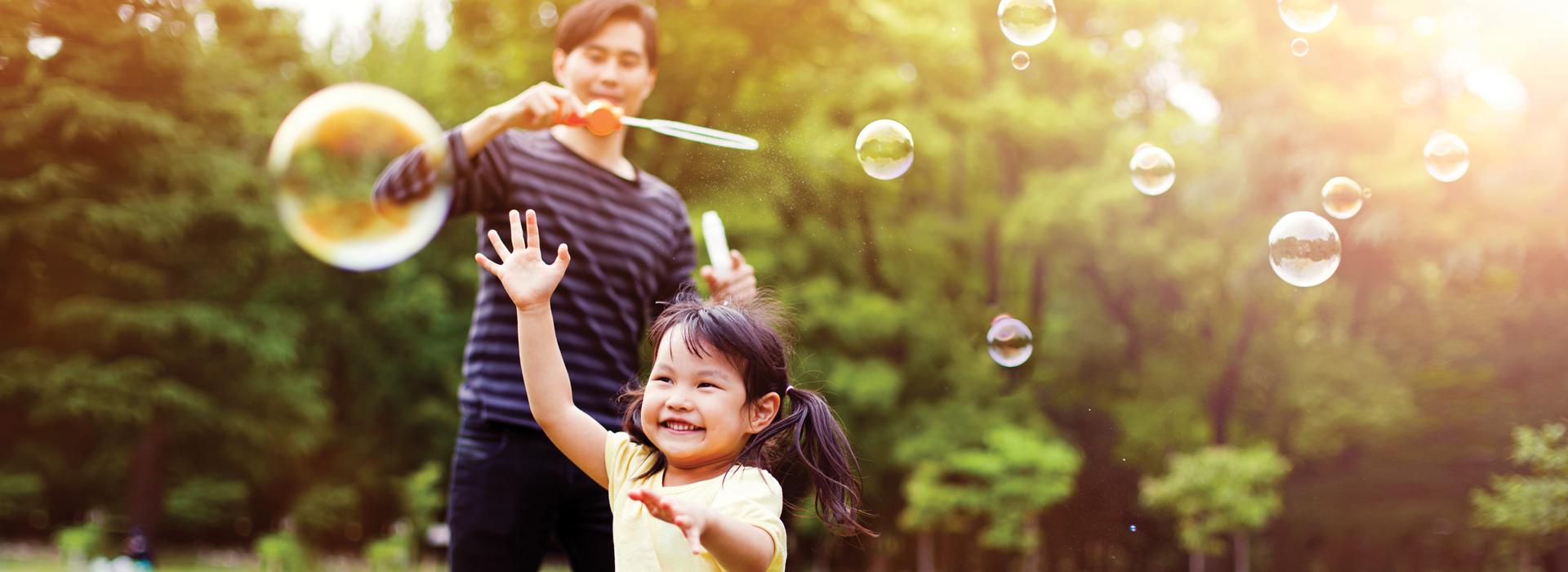Father and daughter playing with bubbles
